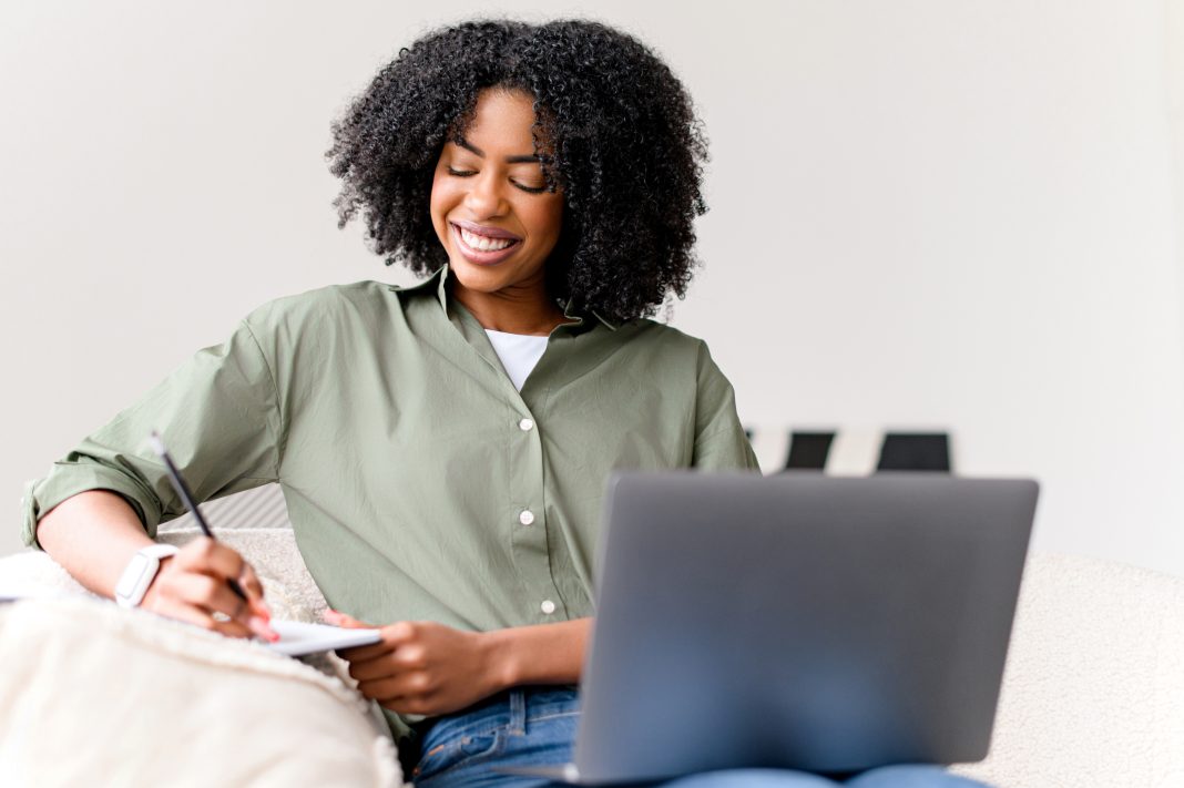 A,Cheerful,African-american,Woman,Works,On,Her,Laptop,While,Sitting planificación